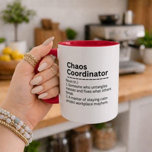 Peut inclure: Un mug en céramique blanche avec un intérieur et une anse rouges. Le mug présente un texte noir qui indique : Chaos Coordinator, Noun (n.), 1. Someone who untangles messes and fixes what others break. 2. A master of staying calm amidst workplace mayhem.