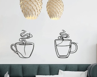 May include: Two black metal wall art pieces depicting coffee cups with steam rising. The artwork is mounted on a white wall above a teal sofa. The room also features a wooden floor lamp, a coffee table, and a wooden cabinet.