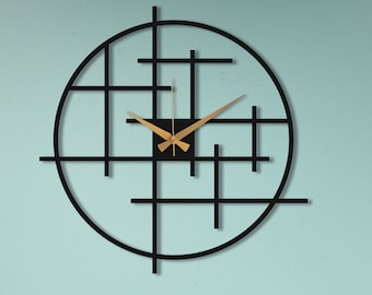 May include: A black and gold modern wall clock with a geometric design. The clock is hanging on a light blue wall above a wooden dresser with two drawers.