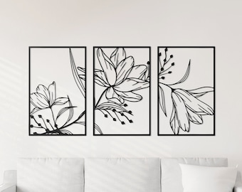 May include: Three black framed wall art prints with a floral design. The prints are arranged in a row on a white wall above a white couch.