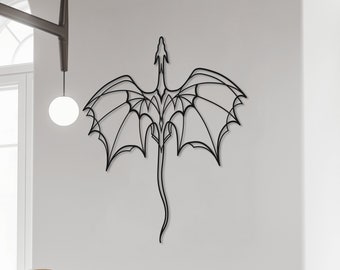 Puede incluir: Arte de pared de metal negro que representa un dragón estilizado con las alas extendidas. El dragón está delineado con una línea negra fina y se coloca contra una pared blanca.