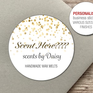Peut inclure: Autocollant rond blanc avec des confettis dorés et le texte "Scent Here???? scents by Daisy HANDMADE WAX MELTS". L'autocollant a une bordure blanche et est sur une surface brun clair.