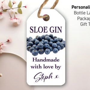 Könnte beinhalten: Weißer Geschenkanhänger mit violetter Schrift, die "SLOE GIN" lautet, und einem Haufen blauer Beeren. Der Text unter den Beeren lautet "Handmade with love by Steph x".