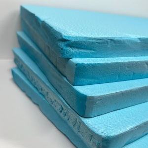 May include: Stack of four light blue foam insulation boards.