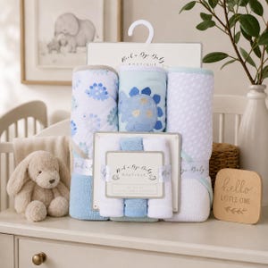 Peut inclure: Un ensemble Rock a Bye Baby Boutique comprenant trois serviettes à capuche et trois gants de toilette dans des tons bleu, blanc et vert menthe. Les serviettes présentent des motifs de dinosaures et une grande applique, tandis que les gants sont unis.