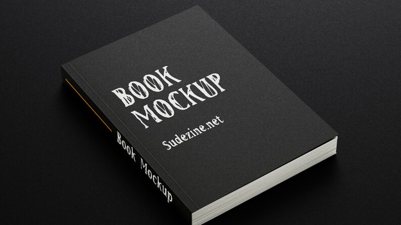 May include: A black book mockup with the text "BOOK MOCKUP" and "Sudezine.net" printed on the cover.