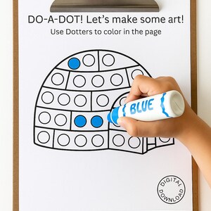 Puede incluir: Un portapapeles sostiene una hoja blanca con un contorno de iglú y el texto "DO-A-DOT! Let's make some art!". Una mano usa un rotulador azul para colorear los puntos. El rotulador es blanco con "BLUE" escrito.