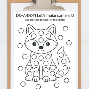 Può includere: Un foglio di attività punto-punto in bianco e nero con un'illustrazione di una volpe. Il foglio è tenuto da una clip board. Il testo in alto recita "DO-A-DOT! Let's make some art! Use Dotters to color in the lights!"