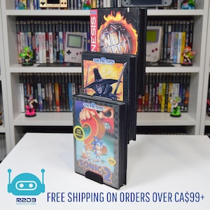 May include: A black display stand holding three Sega Genesis video game cartridges. The cartridges feature the games "NBA Jam", a game with a wizard, and "Sonic 2". The background includes a white shelf filled with video games.