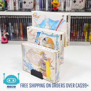 May include: Three vintage Final Fantasy video game boxes stacked on a white surface. The boxes feature colorful illustrations and Japanese text. The bottom box is held by a black stand. The background includes a shelf of video games.