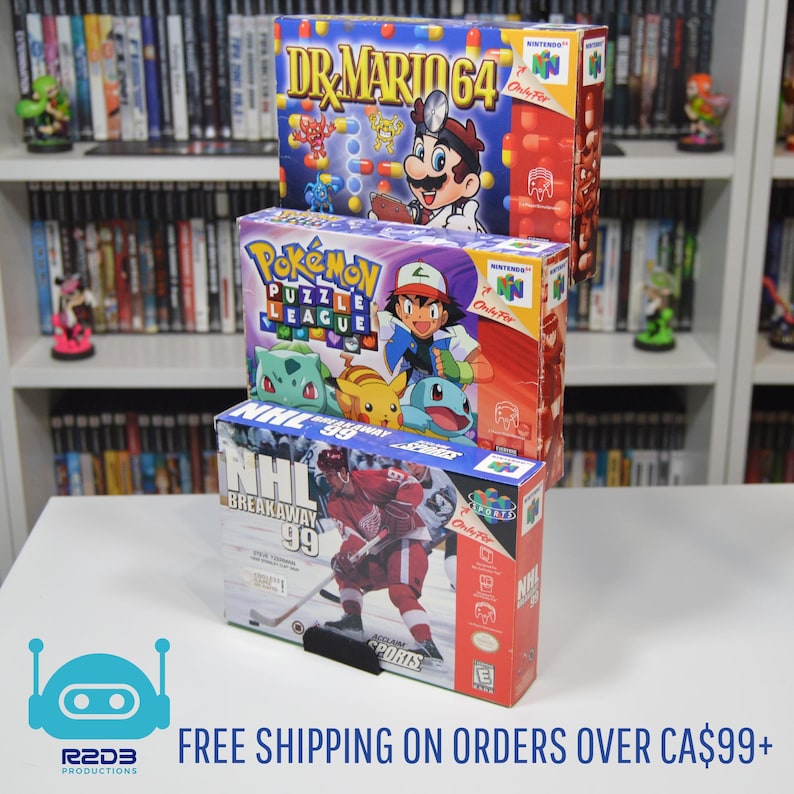 May include: Three Nintendo 64 video game cartridges stacked on top of each other. The top cartridge is Dr. Mario 64, the middle cartridge is Pokemon Puzzle League, and the bottom cartridge is NHL Breakaway '99.