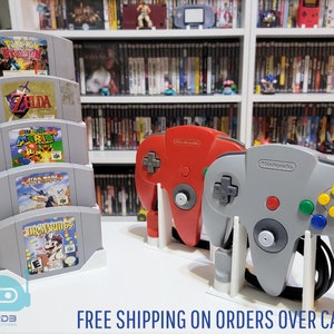 Nintendo 64 用ゲーム階段ディスプレイ 1 台とコントローラースタンド 2 台 (カートリッジ 1 ～ 16 個) のコンボ セット