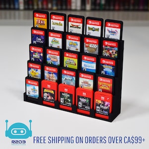 May include: A black display stand holding numerous Nintendo Switch game cartridges. The cartridges are red and black, with game titles visible. The stand is tiered, with multiple rows and columns, displaying a variety of games.