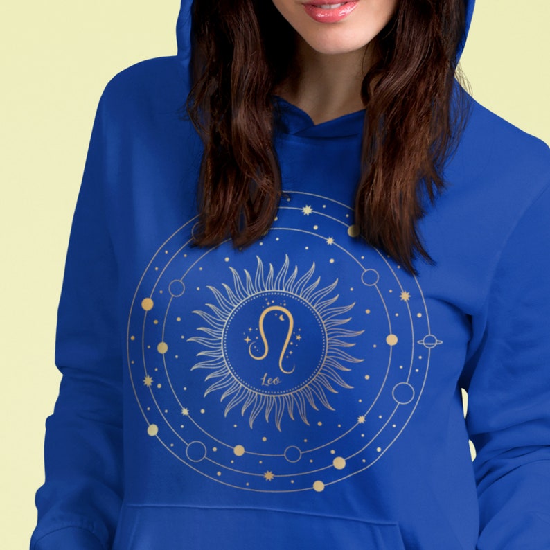 May include: A royal blue hoodie featuring a gold sun and zodiac symbol for Leo. The sun is surrounded by a circle with smaller circles and stars.