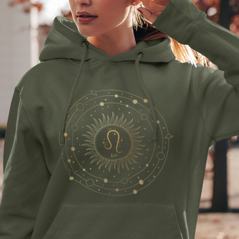 May include: A green hooded sweatshirt with a gold zodiac symbol for Leo, a sun, and the word "Leo" printed on the front.