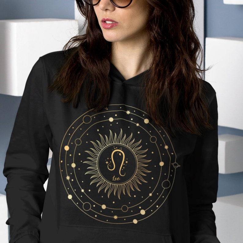 May include: Black hoodie with a gold zodiac design featuring the Leo constellation and the word "Leo" in a circle with a sunburst design.