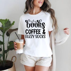 May include: White t-shirt with black text that reads "books coffee & fuzzy socks".