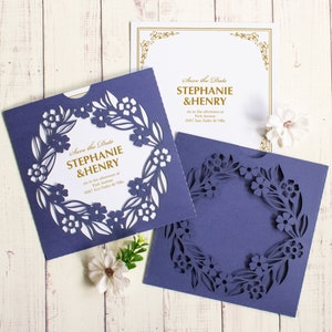 May include: Purple save the date cards with a floral design and the text "Save the Date Stephanie & Henry" in gold lettering.