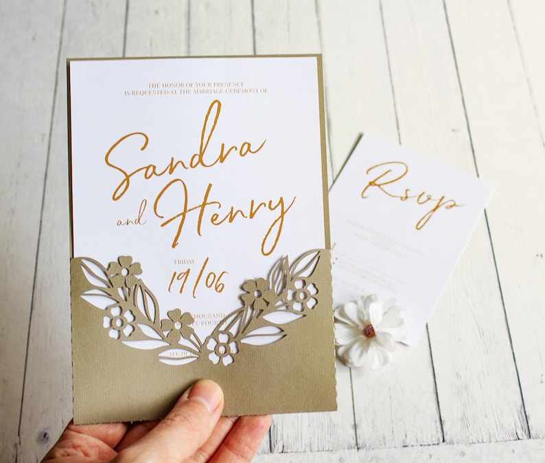 May include: A wedding invitation with a laser cut floral design on the front. The invitation is for Sandra and Henry and the date is 19/06. The RSVP card is also visible.