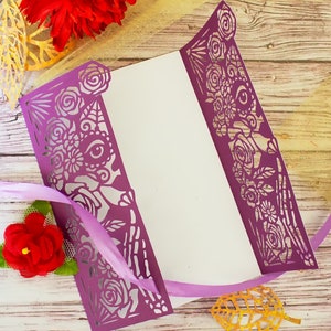 May include: Purple laser cut card with a floral design. The card is folded in half and has a white interior.