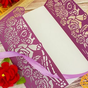 May include: Purple laser cut card with a floral and skull design. The card is folded in half and has a white interior.