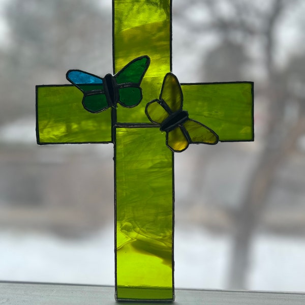 Stained glass cross with butterfly sun catcher.