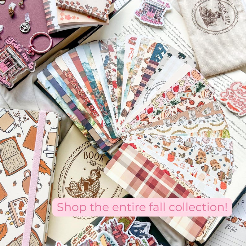 K&ouml;nnte beinhalten: Eine Sammlung von Schreibwaren und Accessoires zum Thema Herbst. Enth&auml;lt gemusterte Lesezeichen, Aufkleber, ein Notizbuch und einen Schl&uuml;sselanh&auml;nger. Der Text "Shop the entire fall collection!" ist sichtbar. Die Artikel sind auf einem offenen Buch angeordnet.