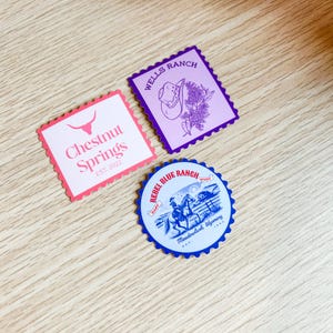May include: Three decorative stickers with a Western theme. One pink sticker with the text "Chestnut Springs" and a bull skull graphic. A purple sticker with a cowboy hat and floral design. A blue and white sticker with a cowboy on a horse.