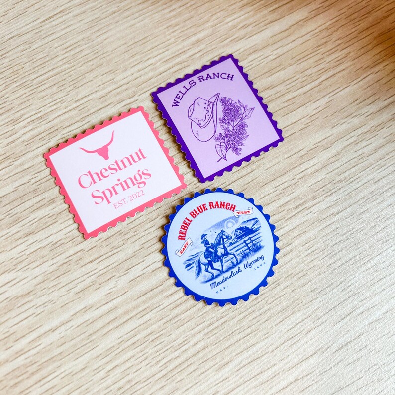 May include: Three decorative stickers with a Western theme. One pink sticker with the text "Chestnut Springs" and a bull skull graphic. A purple sticker with a cowboy hat and floral design. A blue and white sticker with a cowboy on a horse.
