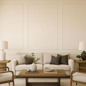 May include: A neutral-toned living room with a cream sofa and dark grey cushions. Wooden side tables with lamps sit either side. A wooden coffee table displays a vase, bowl, and decorative items. Two armchairs complete the scene.