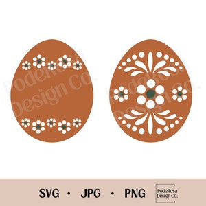 Op de afbeelding: Twee bruine paaseieren met witte bloemmotieven. Eén ei heeft een eenvoudig bloemmotief, terwijl het andere een ingewikkelder motief heeft met een bladontwerp.