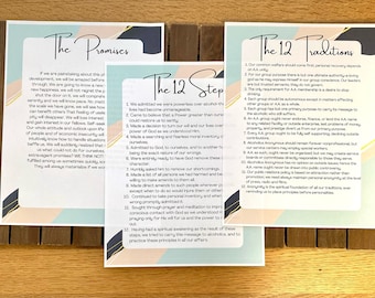 Peut inclure: Trois cartes imprimées avec le texte "The Promises", "The 12 Steps" et "The 12 Traditions" sur une surface en bois. Les cartes sont imprimées sur un fond bleu clair, rose et blanc.