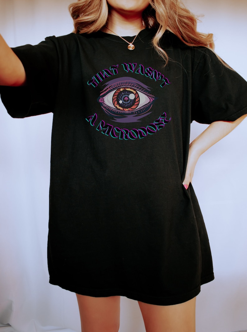 May include: Black oversized t-shirt with a graphic of an eye and the text "That wasn't a microdose".
