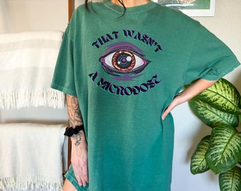 May include: Green oversized t-shirt with a graphic of an eye and the text "That wasn't a microdose".