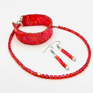 May include: A red iridescent square bead necklace, bracelet and earrings set. The necklace and bracelet are made of small square beads, while the earrings are long and dangle.