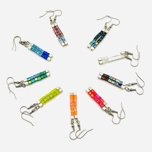 May include: Assortment of colorful iridescent beaded earrings. Each pair features a different color combination of small square beads.