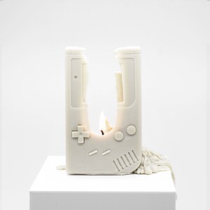 A partially melted candle that looks like the original Nintendo Gameboy.