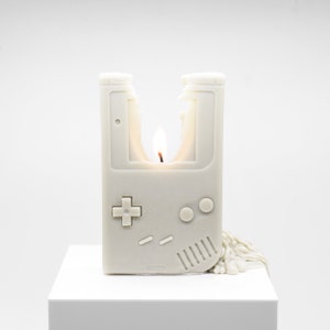 A partially melted candle that looks like the original Nintendo Gameboy.