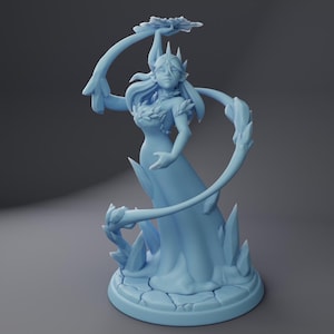 May include: A blue figurine of a female figure with long hair, wearing a flowing gown and holding a flower. She is surrounded by ice crystals.