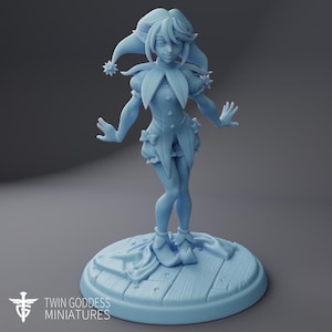 May include: A light blue monochromatic figurine of a jester character wearing a multi-pointed hat with pom-poms, a ruffled collar, and a short tunic. The figure stands on a circular base textured like wooden planks with small star-shaped carvings.