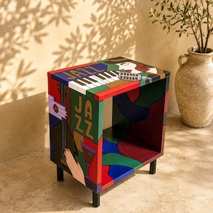 May include: A square side table featuring colorful painted panels with jazz-themed imagery, including piano keys, a double bass, a microphone, and a cocktail glass. The word JAZZ is printed on the top and side panels in bold lettering.