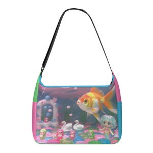 May include: A colorful shoulder bag featuring a whimsical underwater scene. The design includes a large goldfish, a mermaid doll, swans, and other decorative elements. The bag has a black strap and is trimmed with green, pink, and blue.