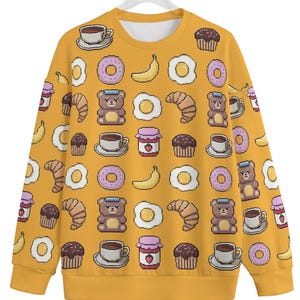 May include: Yellow sweatshirt with a pixelated pattern of breakfast foods, including donuts, eggs, croissants, coffee, jam, and bears.
