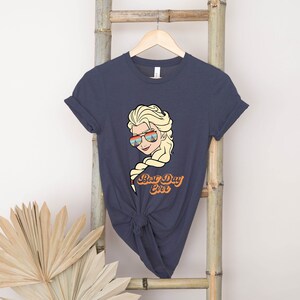 Puede incluir: Una camiseta azul marino con un gr&aacute;fico de un personaje de dibujos animados con gafas de sol y el texto "Best Day Ever".