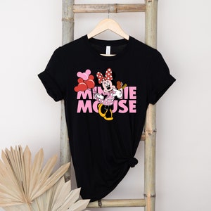 May include: Black t-shirt with a pink and red Minnie Mouse graphic and the text "MINNIE MOUSE" in pink letters.