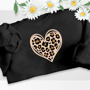 Puede incluir: Sudadera negra con un gran diseño de corazón rosa con estampado de leopardo.