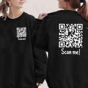 May include: Black sweatshirt with a white QR code and the text "Scan me!" printed on the front.