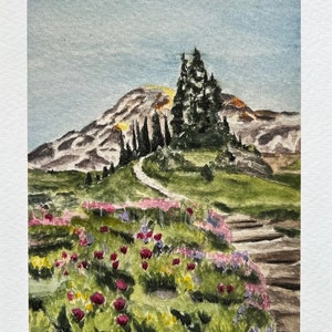 K&ouml;nnte beinhalten: Aquarellmalerei einer Berglandschaft mit einem Pfad, der zu einem Gipfel f&uuml;hrt. Der Vordergrund zeigt eine lebendige Anordnung von Blumen in Rosa-, Rot- und Lilat&ouml;nen. Der Himmel ist ein sanftes Blau, und die gesamte Szene strahlt Ruhe aus.