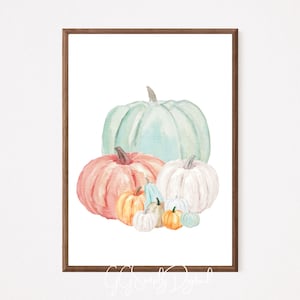 Puede incluir: Pintura acuarela de un grupo de calabazas en varios tonos de azul, verde, naranja y rosa. Las calabazas están dispuestas en un racimo, con la calabaza más grande en la parte superior y las calabazas más pequeñas en la parte inferior.