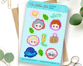 May include: A sticker sheet featuring illustrations of the Golden Girls characters, including cheesecake, a phone, a purse, and a Miami Vice-inspired logo. The sheet is on a light blue background with a white border.